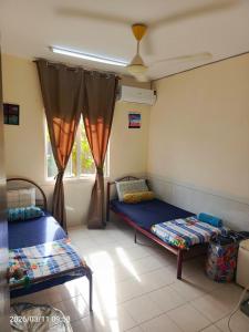 a room with two beds and a window at Homestay No 68 Raub in Raub