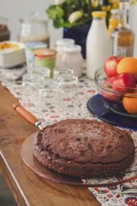 a chocolate cake sitting on a wooden table with a table cloth at Ecovillage Sanctuary Bordei in Palagnedra