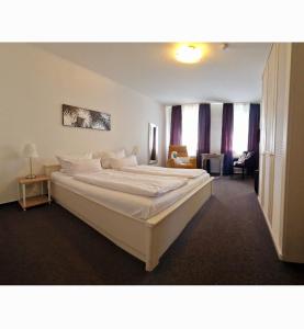 a bedroom with a large white bed in a room at Hotel Stadt Coblenz in Fachbach