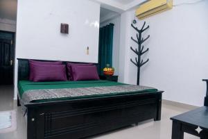 a bedroom with a bed with purple and green at The Lark Resort , Induruwa in Induruwa