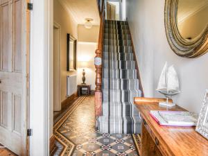 a hallway with a staircase and a mirror at Captain's House in Morfa Nefyn +26 photos