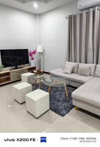a living room with a couch and a tv at Aroyapoolvilla69 in Ban Yep Chaeng
