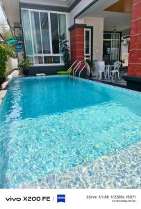 a large blue swimming pool in a house at Aroyapoolvilla69 in Ban Yep Chaeng