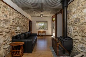 a living room with a black couch and a stone wall at Stony Rise Ranch in Pelican Lagoon