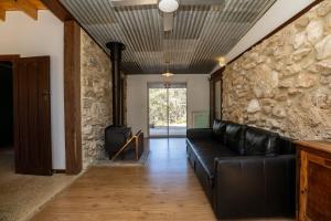 a living room with a leather couch and a stone wall at Stony Rise Ranch in Pelican Lagoon