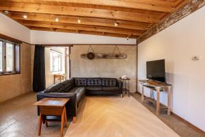 a living room with a leather couch and a tv at Stony Rise Ranch in Pelican Lagoon