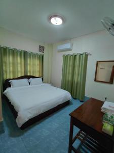 a bedroom with a bed and a desk and a bed sidx sidx sidx at Khopchai Guesthouse in Ban Houayxay