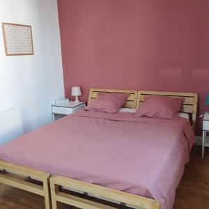 a bedroom with a large bed with purple sheets at La petite maison in Clermont-Ferrand