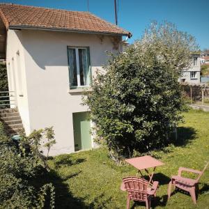 a house with a table and two chairs in the yard at La petite maison in Clermont-Ferrand