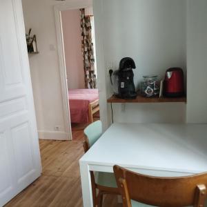 a room with a table and a room with a bed at La petite maison in Clermont-Ferrand