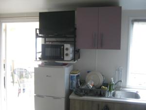 a kitchen with a microwave on top of a refrigerator at erick in Angles