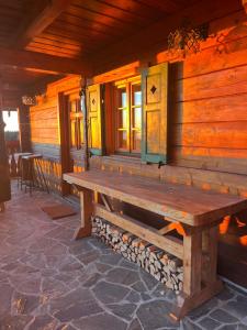 a wooden bench on the side of a cabin at HolidayHouse Mahova koča in Zreče +38 photos