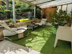 a patio with chairs and a table on grass at Le Coq de Champagne in Dormans