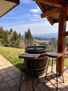 a barrel sitting on a patio with two stools at HolidayHouse Mahova koča in Zreče