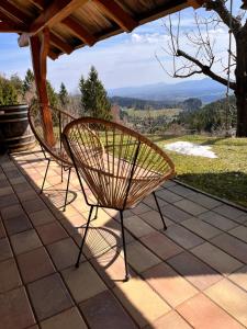 two chairs sitting on a patio with a view at HolidayHouse Mahova koča in Zreče