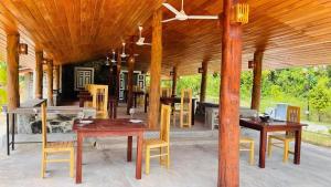 a pavilion with wooden tables and chairs on a patio at The Lark Resort , Induruwa in Induruwa