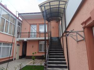 a staircase leading up to a pink building at Bilol Guest House in Samarkand