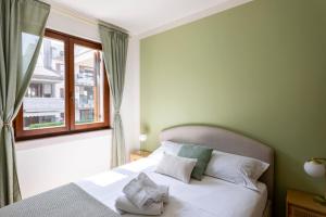 a bedroom with a white bed with a window at Calm House in Desenzano del Garda +10 photos