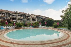 a large swimming pool with chairs and umbrellas at Calm House in Desenzano del Garda