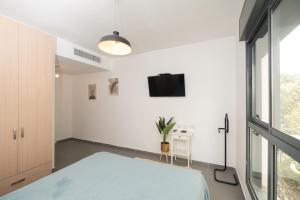 a bedroom with a bed and a tv on the wall at Assuta family in Tel Aviv