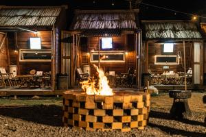 a fire pit in front of a log cabin at Jeju EQ Stay Hotel in Jeju
