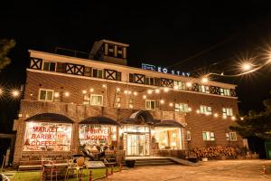 a large brick building with lights on it at night at Jeju EQ Stay Hotel in Jeju