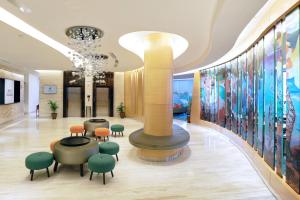 a lobby with a round table and green chairs at Hotel Ciputra Cibubur managed by Swiss-Belhotel International in Cibubur +40 photos