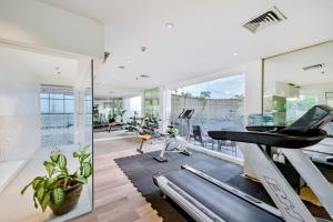 a room with a gym with a treadmill and a elliptical at Hotel Ciputra Cibubur managed by Swiss-Belhotel International in Cibubur