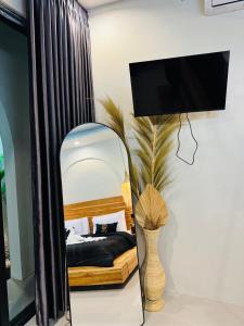 a bedroom with a bed with a mirror and a tv at Pinggan Tavora in Gretek