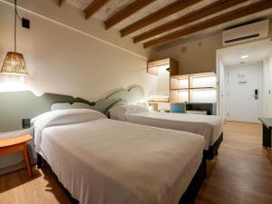 a hotel room with three beds in a room at Ibis Styles Maragogi in Maragogi