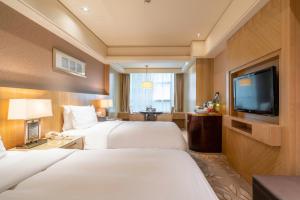 a hotel room with two beds and a flat screen tv at C&D Hotel Quanzhou in Quanzhou +37 photos