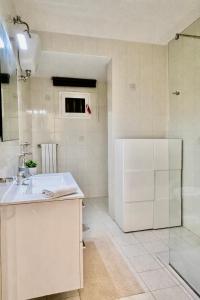 a white kitchen with a sink and a refrigerator at The Urban Lodge in Bari