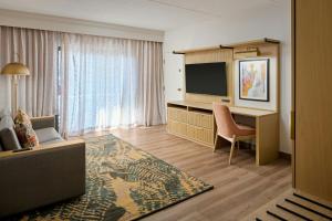 a hotel room with a desk and a television at Courtyard Virginia Beach Norfolk in Virginia Beach