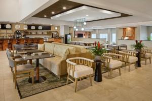 a restaurant with a couch and tables and chairs at Courtyard Virginia Beach Norfolk in Virginia Beach