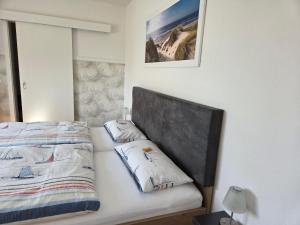 a bed with two pillows on it next to a mirror at Gästehaus Arkona in Tönning