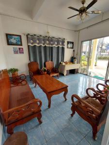 a living room with couches and a table and chairs at Khopchai Guesthouse in Ban Houayxay