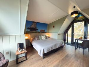 a bedroom with a bed and a table with a fireplace at Hotelhuisjes Medemblik in Wieringerwerf