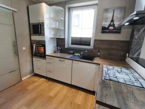 a kitchen with white cabinets and a sink and a window at Hehlentor Fachwerkwohnung in Celle