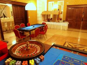 una habitación con una mesa de ruleta y sillas en un casino en Korona Palace, en Leżnica Wielka