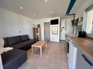 a kitchen and a living room with a couch and a table at Super studio aux portes de Bordeaux ! in Gauriaguet