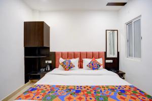 a bedroom with a large bed with colorful pillows at FabHotel Swastik Villa in Varanasi