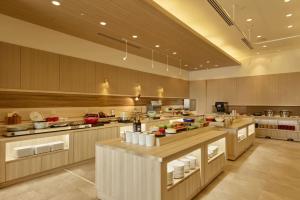 a large kitchen with alot of food on the counters at Hotel Nikko Northland Obihiro in Obihiro
