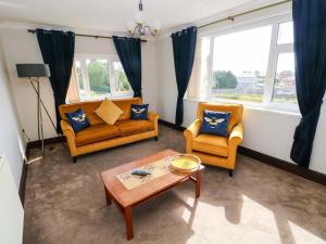 a living room with two couches and a coffee table at Graig Goch in Burry Port