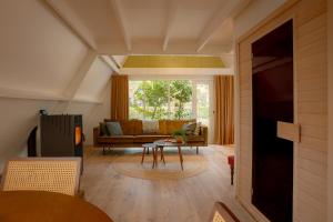 a living room with a couch and a table at Boshuisje Rekem - Nirvana in Lanaken