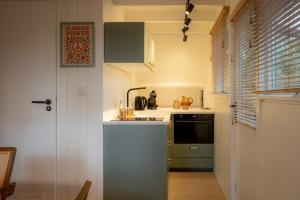 a small kitchen with a sink and a stove at Boshuisje Rekem - Nirvana in Lanaken +16 photos