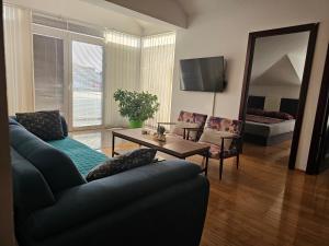 a living room with a couch and a table and a mirror at Apartmani Mašić Trebinje in Trebinje