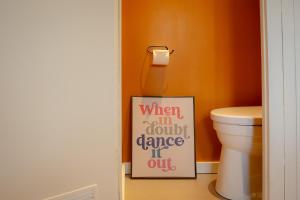 a bathroom with a toilet and a sign on the floor at Boshuisje Rekem - Nirvana in Lanaken