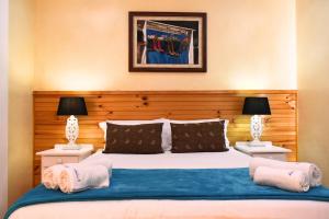 a bedroom with a large bed with two lamps at Dibiki Holiday Resort in Hartenbos +63 photos