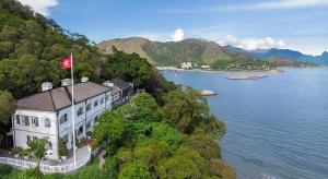 a building on a hill next to a body of water at Tai O Heritage Hotel in Hong Kong