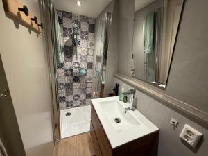 a bathroom with a sink and a shower at Hotelhuisjes Medemblik in Wieringerwerf